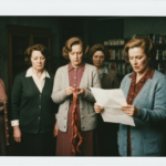 Group of women examining organs and papers in a dimly lit, vintage setting.