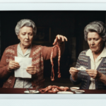Two women in vintage clothing perform haruspicy, examining organs and paper.